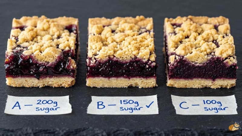 Cross-section comparison of three black currant crumble bar pectin:sugar ratios — Ratio A over-gelled, Ratio B firm and jammy, Ratio C reduced sugar